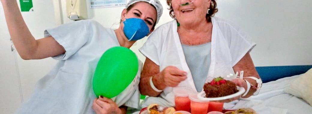 Paciente Flora Teodoro comemorando seus 82 anos com equipe do Hutrin em acolhimento musical. Foto: Divulgação.